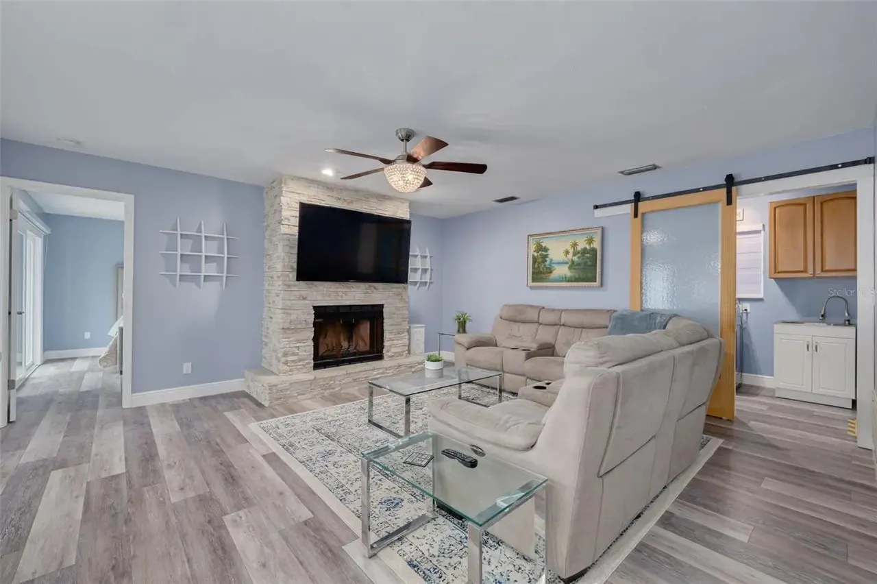 LVP living room stone fireplace barn door Holiday FL