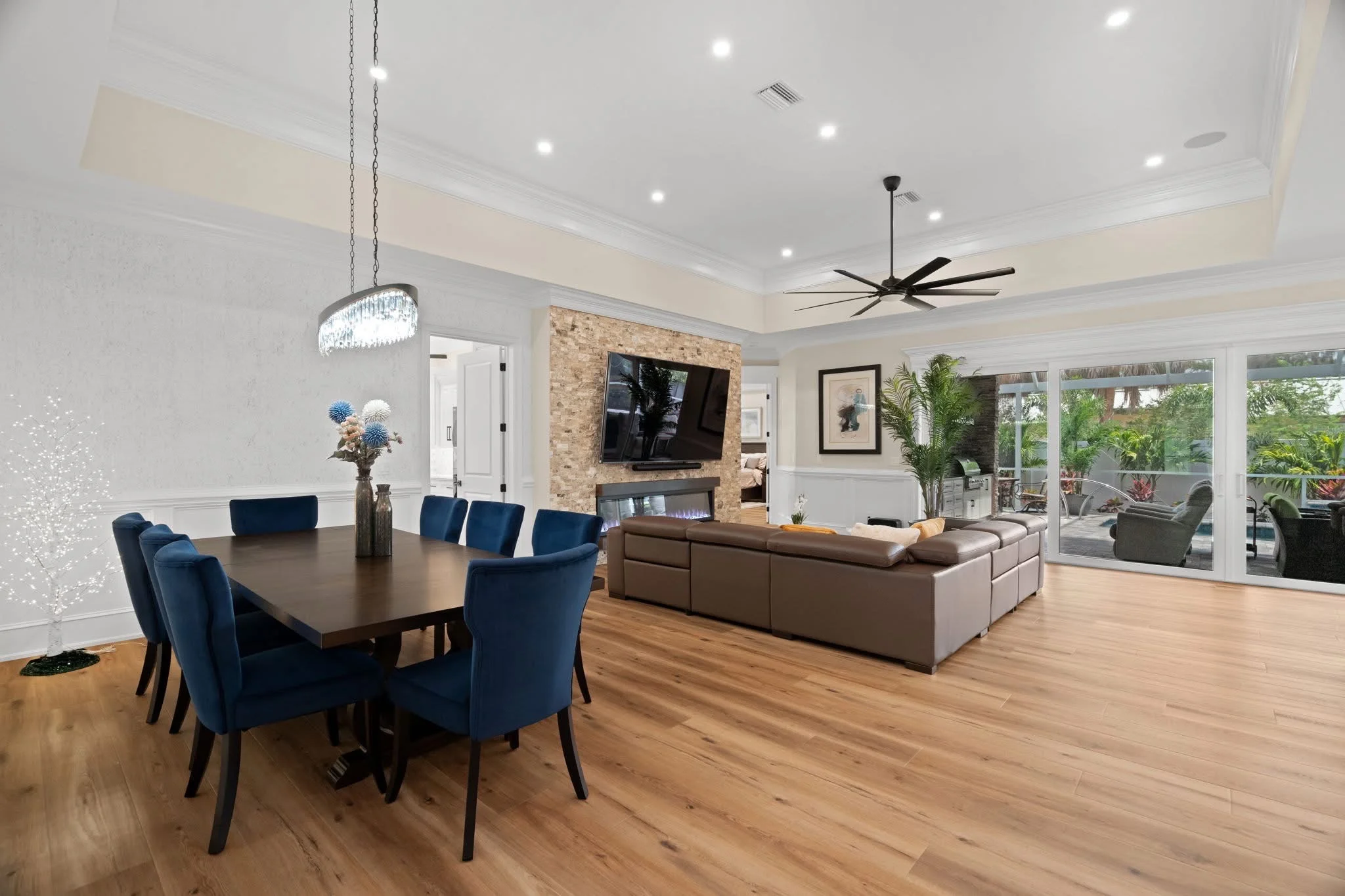 Luxury vinyl plank flooring in a bright open-plan living room with wood beam ceiling — Holiday, FL